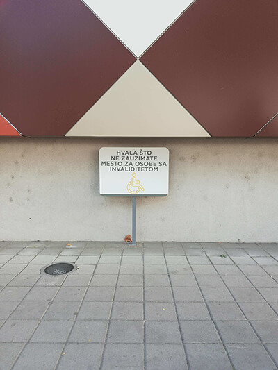 табла на обележеном паркинг месту на којој пише хвала што не заузимате место за особе са инвалидитетом